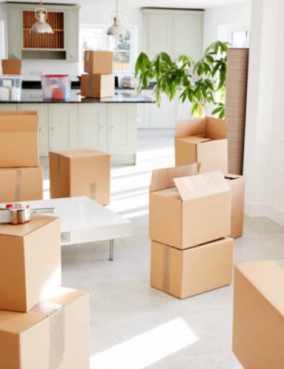 Stacked Removal Boxes In Empty Room On Moving Day